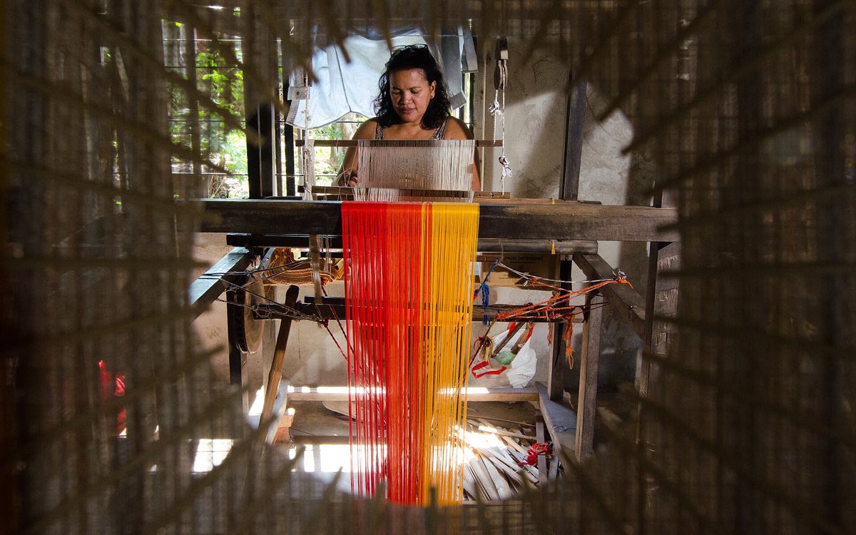 A weaver at a handloom in the Philippines